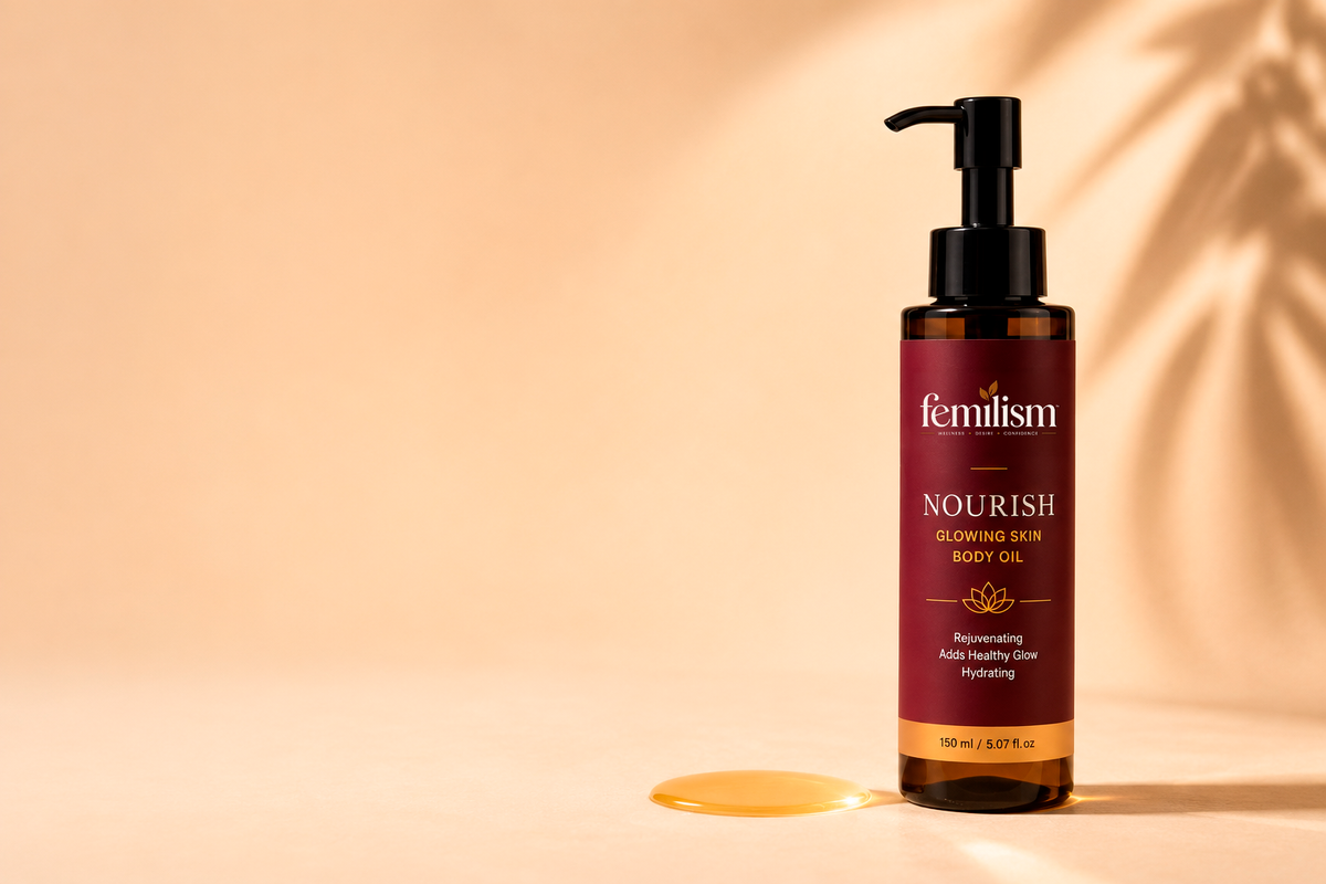 Femilism Nourish glowing skin body oil beside a pool of golden oil on a warm cream background